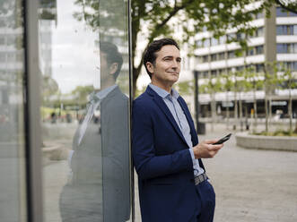 Mature businessman with smartphone in the city - JOSEF01189