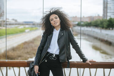 Young afro woman leaning on railing - KIJF03186