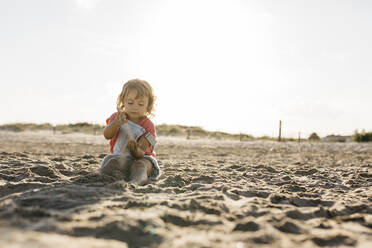 Mädchen spielt mit Sand am Strand im Sommer - JRFF04557