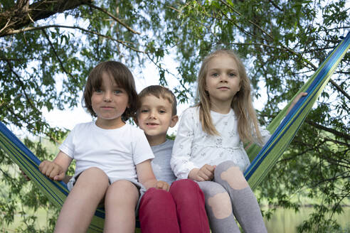 Cute children sitting on hammock in forest - VPIF02561