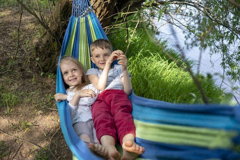Cute children relaxing on hammock in forest - VPIF02562