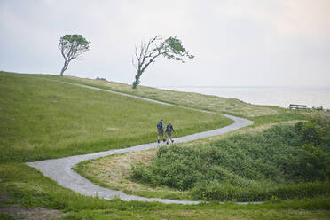 Two people walking along a coastal path - CUF55531