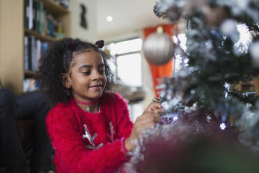 Mädchen schmückt Weihnachtsbaum - CAIF28174