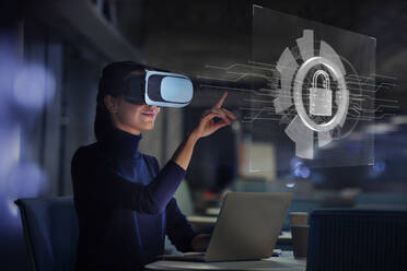 Geschäftsfrau mit Virtual-Reality-Brille am Laptop - CAIF28188