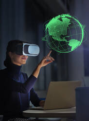 Geschäftsfrau mit Virtual-Reality-Brille berührt virtuellen Globus - CAIF28194