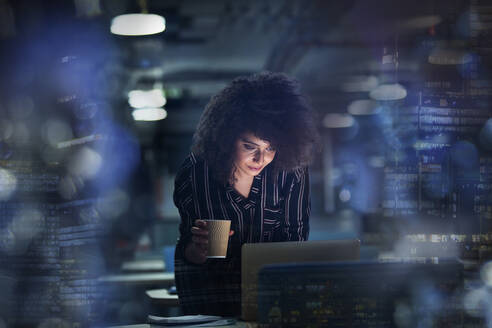 Geschäftsfrau arbeitet spät am Laptop mit Kaffee - CAIF28200