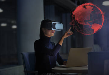 Geschäftsfrau mit Virtual-Reality-Brille berührt virtuellen Globus - CAIF28206