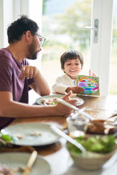 Vater und Sohn essen und malen am Tisch - CAIF28227