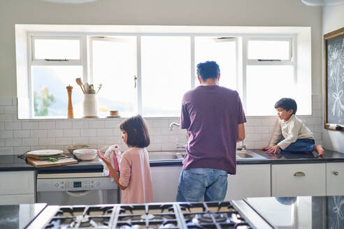 Familie beim Abwaschen am Spülbecken - CAIF28231