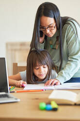 Mother helping daughter with homework - CAIF28232