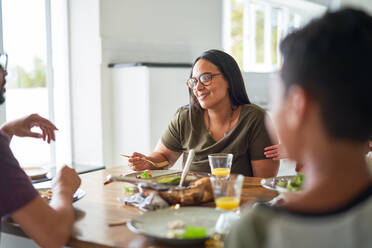 Glückliche Familie beim Abendessen am Tisch - CAIF28233