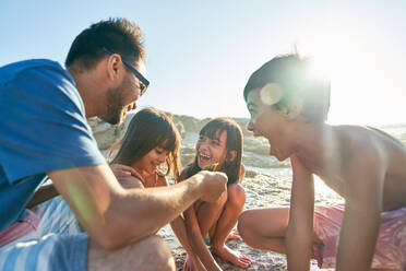 Glückliche Familie spielt am sonnigen Strand - CAIF28251
