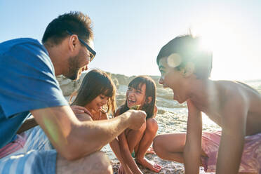 Happy family playing on sunny beach - CAIF28251