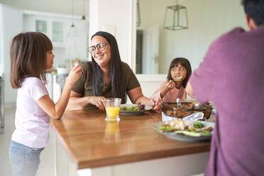 Happy family eating lunch at table - CAIF28267