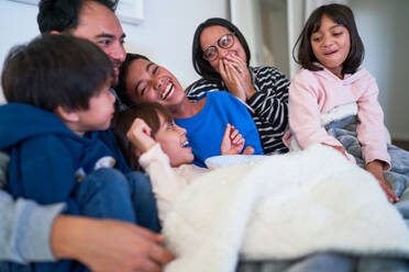 Glückliche Familie lachend auf dem Sofa - CAIF28271