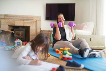 Happy mother exercising and watching daughter drawing - CAIF28276