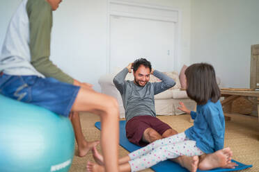 Vater und Kinder trainieren im Wohnzimmer - CAIF28303