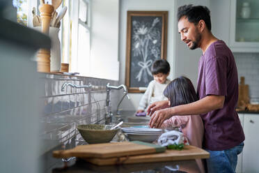 Vater und Kinder beim Abwaschen an der Spüle - CAIF28320