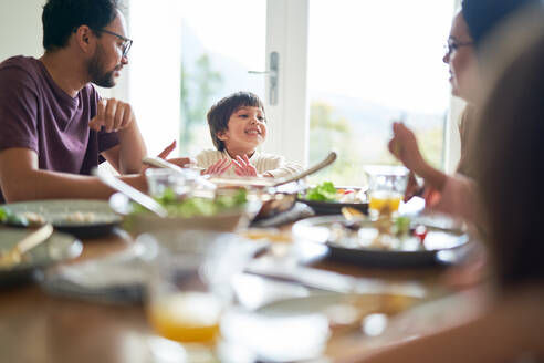 Glückliche Familie beim Mittagessen am Esstisch - CAIF28323