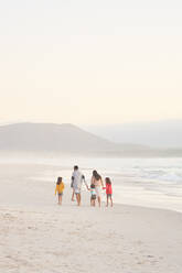 Family walking on ocean beach, Cape Town, South Africa - CAIF28356