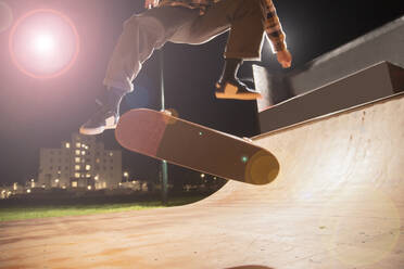 Junger Mann fährt Skateboard auf einer Rampe im Skatepark - CAIF28381