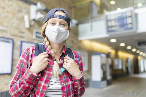 Close-up of woman with braided hair wearing mask and cap while standing at tube station - WPEF03210