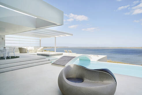 Design-Sessel am Pool eines luxuriösen Strandhauses - RORF02224