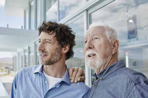 Porträt eines älteren Mannes mit einem erwachsenen Sohn in einem Strandhaus - RORF02236