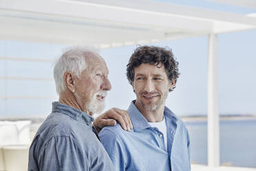 Porträt eines älteren Mannes mit erwachsenem Sohn in einem Strandhaus - RORF02238