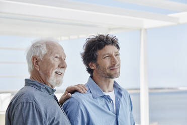 Porträt eines älteren Mannes mit einem erwachsenen Sohn in einem Strandhaus - RORF02241