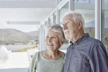 Portrait of smiling senior couple at luxury beach house - RORF02272