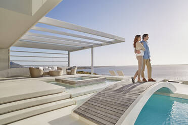 Couple standing on bridge above a swimming pool enjoying the view - RORF02311