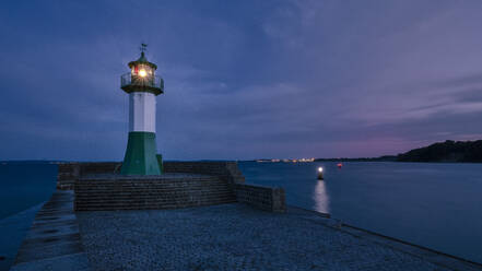 Germany, Mecklenburg-Western Pomerania, Sassnitz, Small lighthouse on shore of Rugen island at night - HAMF00674