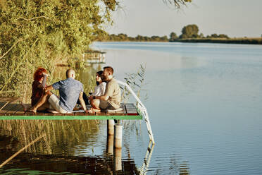 Freunde beim Picknick auf dem Steg eines Sees - ZEDF03590