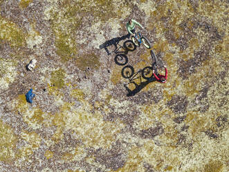 Russland, Gebiet Murmansk, Bezirk Kolsky, Teriberka, Zwei Männer auf dem Fahrrad an der Küste, Luftaufnahme - KNTF04882