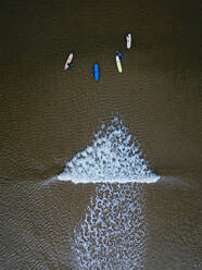 Luftaufnahme von Menschen beim Surfen im braunen Wasser der Barentssee - KNTF04887