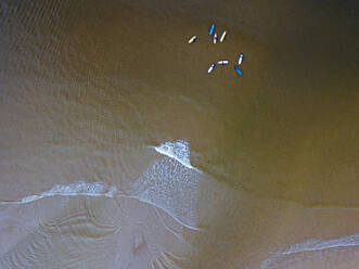 Luftaufnahme von Menschen beim Surfen im braunen Wasser der Barentssee - KNTF04892