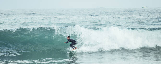 Panoramaaufnahme eines professionellen Surfers und Wellenreiters auf einem Surfbrett, Barcelona - ADSF00095