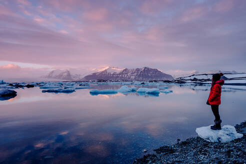 Side view of unrecognizable tourist standing at icy lake in Iceland. - ADSF00106