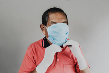 Senior man wearing protective mask and gloves - DSIF00008