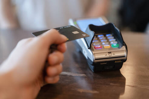 Mann zahlt mit Kreditkarte im Restaurant - DIGF12749
