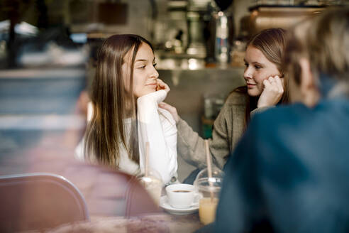 Teenager-Mädchen sieht ihren Freund an, während sie in einem Café sitzt - MASF18658