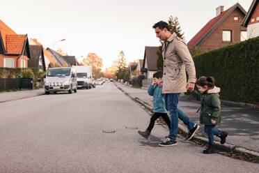 Vater überquert mit Kindern im Herbst den Fußweg - MASF18832