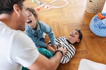 High angle view of father playing with children at home - MASF18851