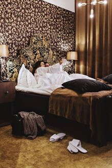 Erwachsene Frau, die Selfie mit Freund auf dem Bett im Hotelzimmer - MASF18897