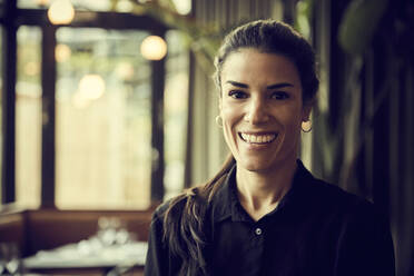 Portrait of happy owner standing in cafe - MASF18918