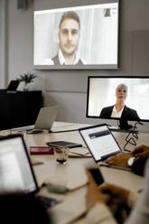 Männliche und weibliche Fachkräfte besprechen sich per Videokonferenz mit ihrem Team bei einer Besprechung im Büro - MASF18961