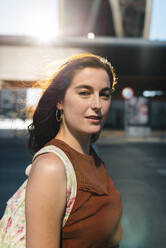 Confident mid adult woman standing on city street during sunny day - JMPF00140