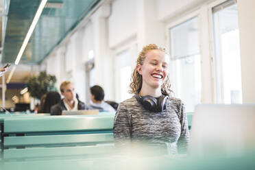 Lächelnde junge Studentin in der Cafeteria - MASF19118