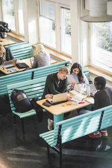 Männliche und weibliche Studenten lernen am Tisch in der Cafeteria - MASF19127